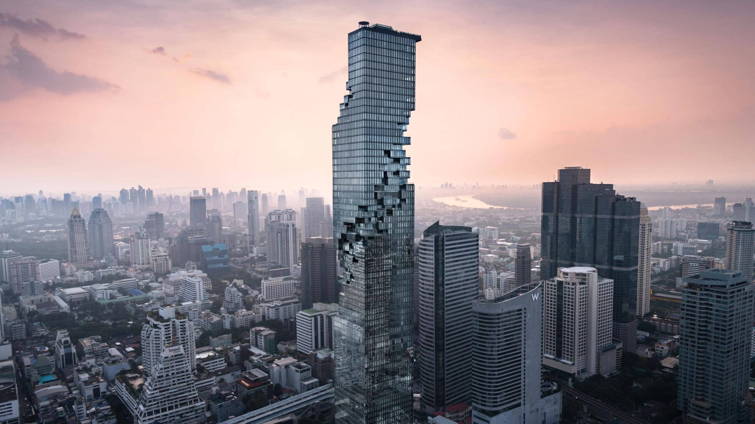 Las Pixel Tower rodeada de edificios que pertenece a una ciudad llamada Bangkok en Tailandia en una atardecer espectacular