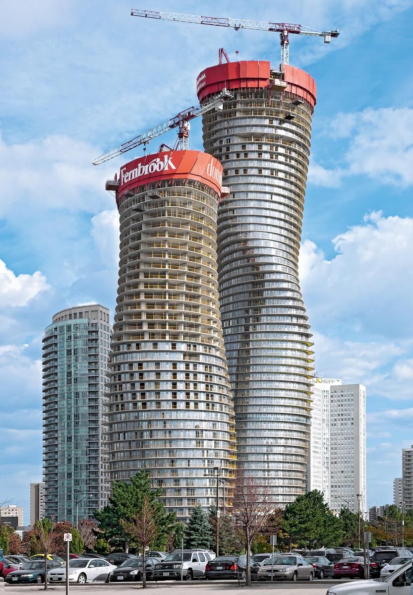 La imagen muestra las Absolute Towers en Mississauga, Canadá, durante el proceso de construcción. Estas torres, diseñadas por MAD Architects, rompen con la rigidez de los rascacielos convencionales al presentar una estructura fluida y dinámica, lo que les ha valido el apodo de Las Marilyn Monroe de la arquitectura.